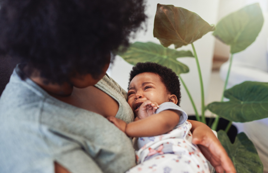 Black mother holding crying baby