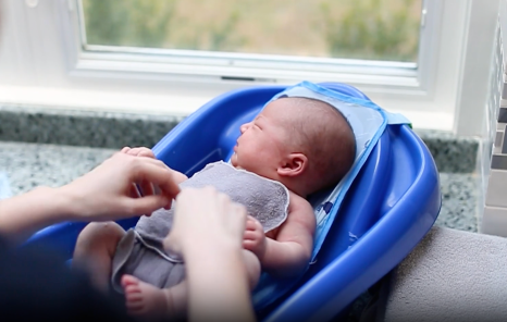 Newborn baby being bathed 