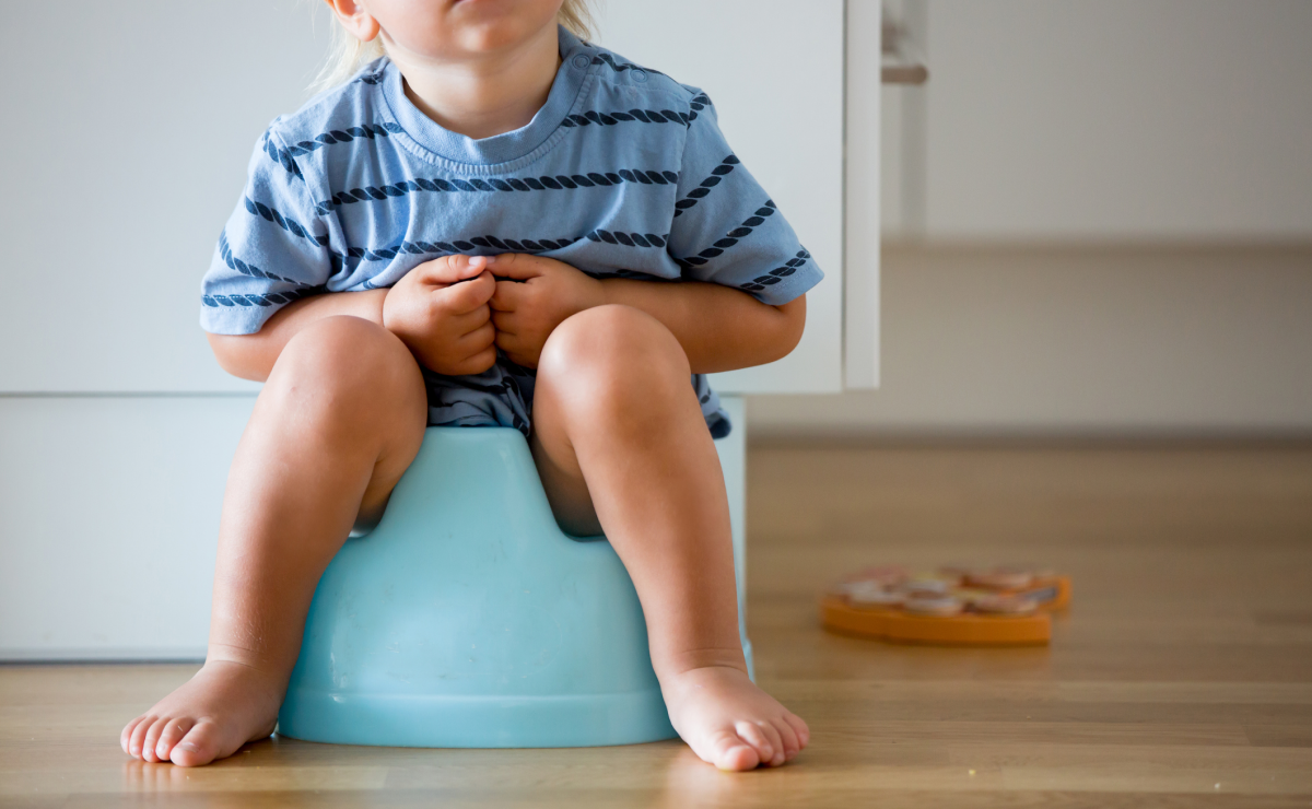 Toddler boy on blue potty